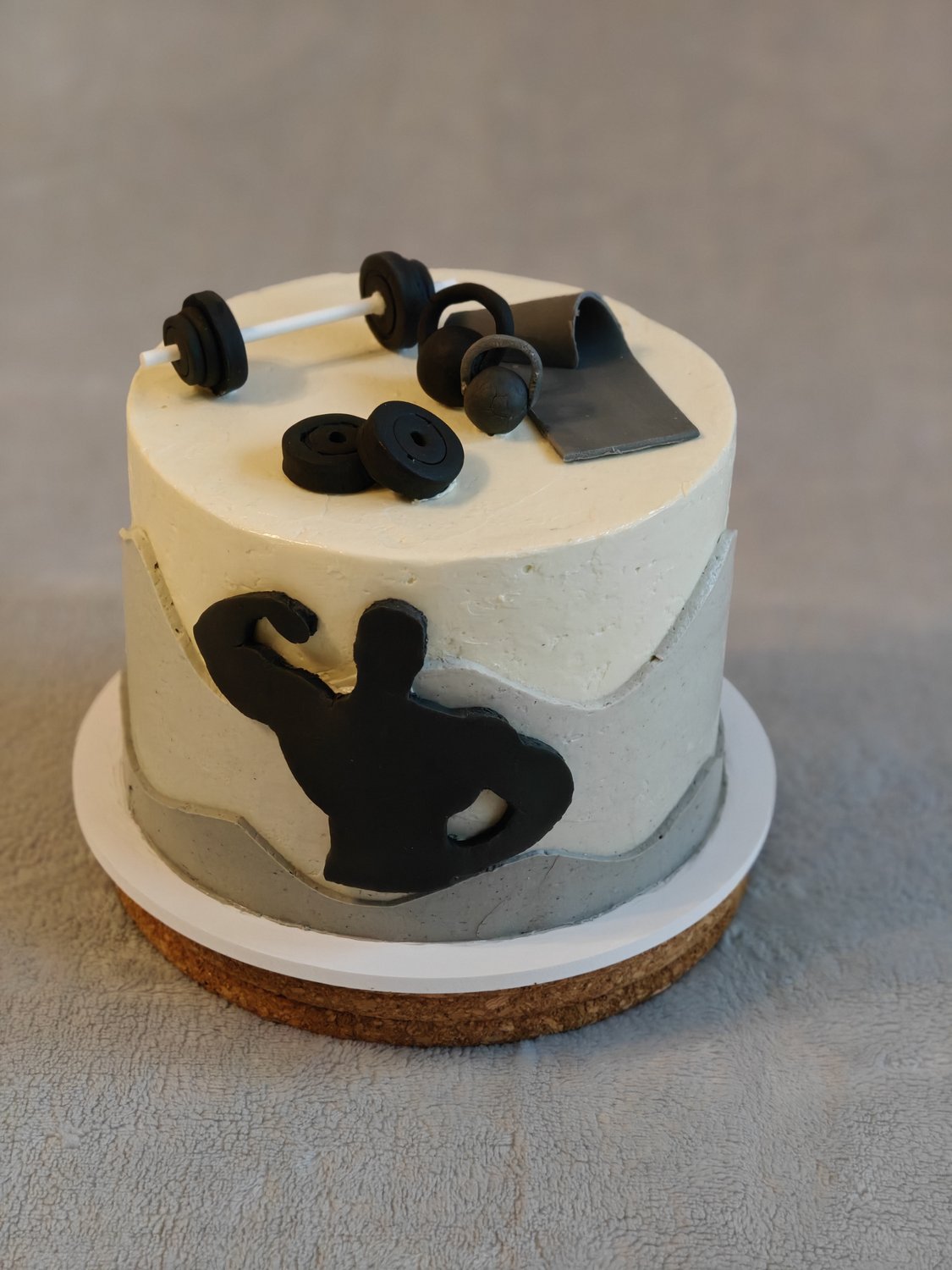 Two-tier fitness themed cake with fondant muscleman silhouette